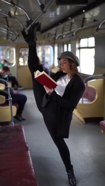 Chica flexible de pie con la división en el metro y libro de lectura. Concepto de creatividad, individualidad y confianza en sí mismo — Vídeo de stock