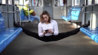 Esnek kız akıllı telefonuyla yeraltı vagonunda oturuyor. Yaratıcılık, bireysellik ve kendine güven kavramı