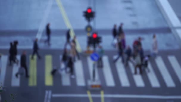 Размытая толпа людей, переходящих дорогу с светофорами в замедленной съемке — стоковое видео
