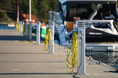 Botlar için şarj istasyonu, marinanın boş limanında yelkenlileri şarj etmek için elektrik prizleri.