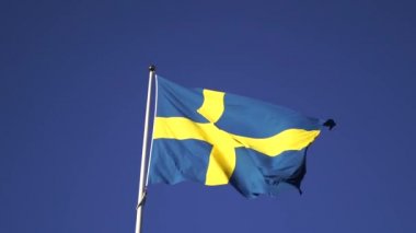 İsveç bayrağı rüzgarda dalgalanıyor arka planda 4k