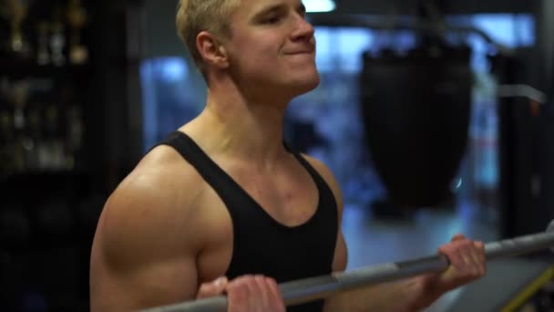 Muskulös bodybuilder killen gör övningar i gym. Begreppet viljestyrka, motivation och passion — Stockvideo