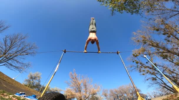 Gymnast gjør triks på vannrett bar utendørs. Viljestyrke, motivasjon og lidenskap – stockvideo