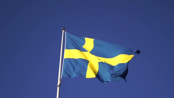 Schwedische Flagge flattert im Wind am Himmel Hintergrund 4k — Stockvideo