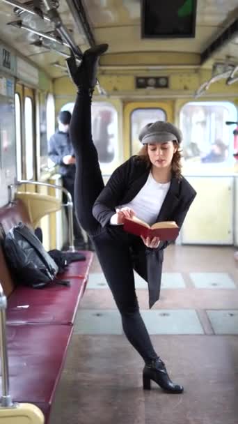 Очень гибкая женщина читает книгу в вагоне метро, стоящей в спортзале. Концепция здорового образа жизни и образования — стоковое видео