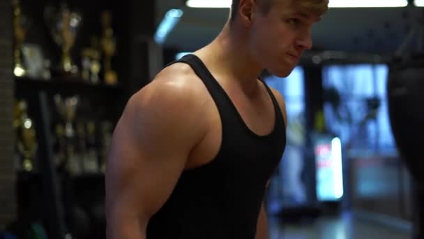 Μυώδης bodybuilder τύπος κάνει ασκήσεις στο γυμναστήριο. Έννοια της θέλησης, των κινήτρων και του πάθους — Αρχείο Βίντεο