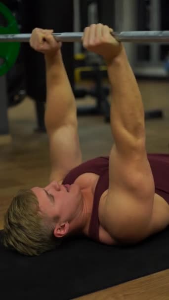 Musculaire bodybuilder man doet oefeningen in gym.Concept van verlangen, wil en potentieel. 4k Verticaal schot — Stockvideo
