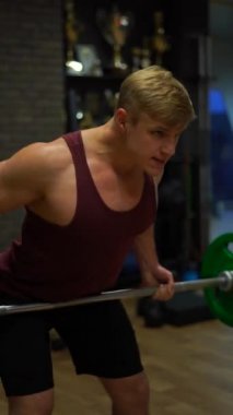 Spor salonunda egzersiz yapan kaslı vücutçu. Arzu, irade ve potansiyel kavramı. 4k dikey çekim 