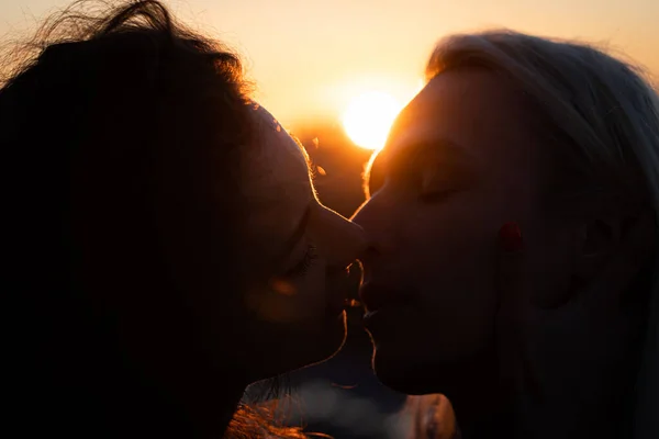 Silueta de pareja joven romántica besándose al atardecer. Comienzo del amor y la relación —  Fotos de Stock