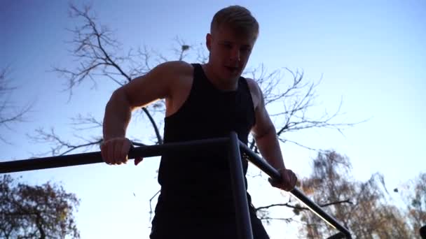 Hombre musculoso haciendo calistenia en el fondo del cielo atardecer. Estilo de vida saludable y concepto de entrenamiento — Vídeos de Stock