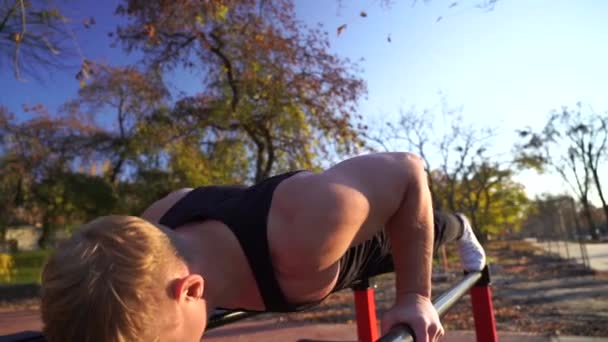 Svalnatý muž dělá na pozadí západu slunce. Kalisthenika, zdravý životní styl a koncepce cvičení — Stock video