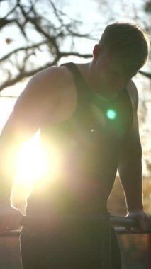 Gün batımında dışarıda spor yapan kaslı bir adam. Sağlıklı yaşam tarzı ve egzersiz konsepti. dikey görüntüler 