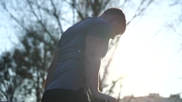 Gespierde man op zonsondergang hemel achtergrond. Calisthenics, gezonde levensstijl en workout concept — Stockvideo