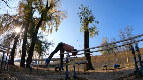 Gimnasta hace trucos en barras paralelas al aire libre. Concepto de fuerza de voluntad, motivación y pasión — Vídeos de Stock