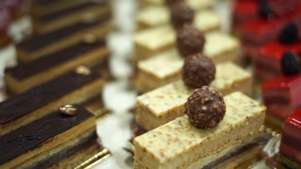 Primer plano de pasteles dulces recién horneados y pasteles en fila en el mercado de alimentos — Vídeos de Stock