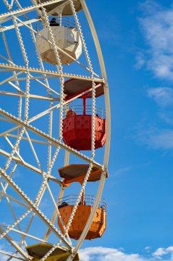 Mavi gökyüzüne karşı renkli bir dönme dolabın yakın çekimi. Tatil, tatil kavramı