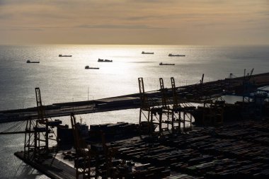 Gün batımında Barcelona Kargo Limanı Terminalleri Nakliye ve İskeledeki Tesisler 'in Silueti
