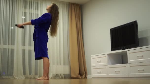 Mujer flexible ejercitándose en casa delante de la pantalla de televisión, estirando su espalda. Concepto de individualidad, creatividad y confianza en sí mismo — Vídeos de Stock