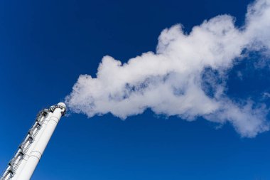 Mavi gökyüzüne karşı borulardan çıkan dumandan kaynaklanan hava kirliliği. Çevre kirliliği, çevre sorunları ve emisyonları kavramı