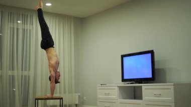 Amuda kalkıp televizyon izleyen kaslı bir adam. Özgünlük, yaratıcılık ve olağanüstü kavramı