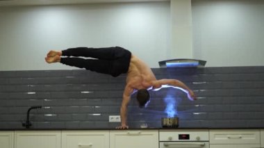 Adam bir elinde dengesini koruyor ve mutfakta yemek pişiriyor. İrade, motivasyon ve tutku kavramı