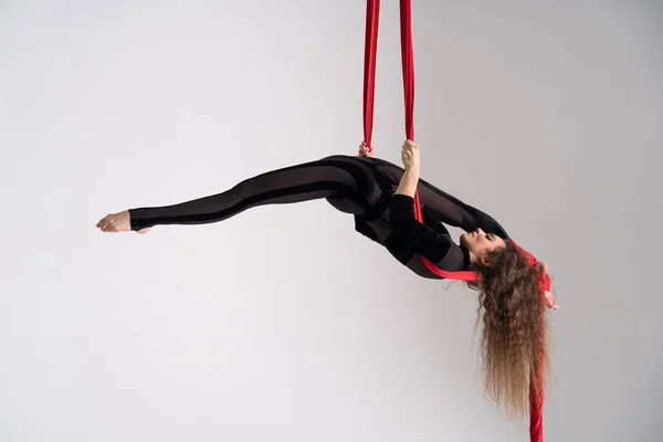 Flexible Female Circus Artist Performs Red Aerial Silk White Background — Stockfoto