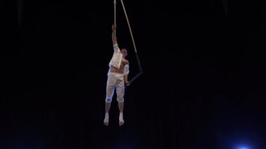 Muscular male air circus artist performances with dance trapeze. Concept of Individuality and creativity .