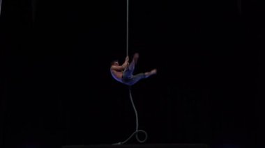 Muscular and fit circus artist perform on aerial rope on high altitude. High quality 4k footage