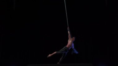 Muscular and fit circus artist perform on aerial rope on high altitude. High quality 4k footage