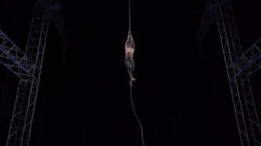 Muscular and fit circus artist perform on aerial rope on high altitude. High quality 4k footage