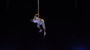 Muscular male air circus artist performances with dance trapeze. Concept of Individuality and creativity .