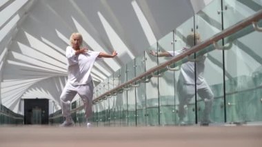 Female Dancer On The Modern urban bridge. Caucasian Young Girl in white clothes dance Rhythmically.
