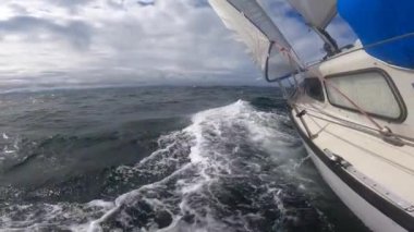 Sailboat Hull Cutting Through Water bending on the side through stormy weather, Bow Wave Slow Motion.