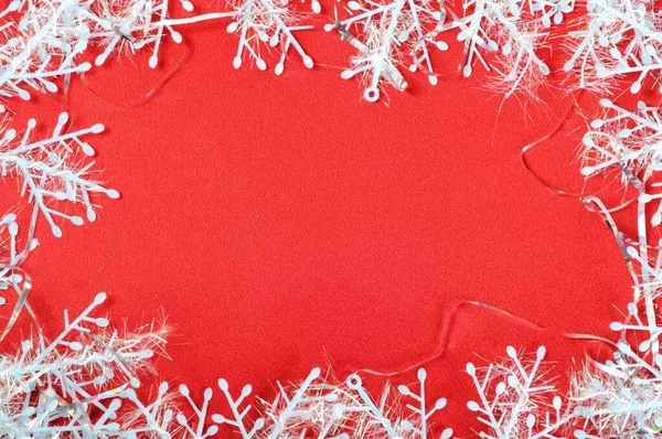 Copos de nieve decorativos sobre fondo de seda textil rojo — Foto de Stock