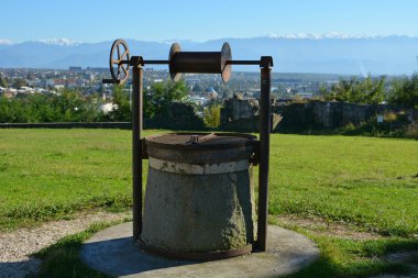 Old Water Well at the Bagrati Cathedral yard, view of the Caucasus Mountains and city of Kutaisi, Georgia clipart