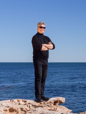 Deniz kenarında gülümseyen yakışıklı emin olgun adam