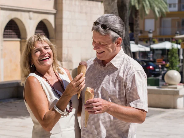 Lachen volwassen senior koppel eten van ijs plezier — Stockfoto