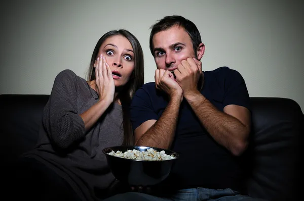 Jovem casal assistindo filme assustador na tv — Fotografia de Stock