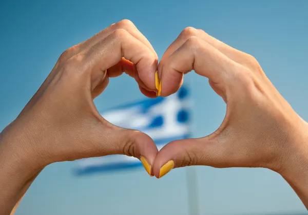 Ich liebe die Geste des griechischen Herzens mit der griechischen Flagge im Hintergrund Stockbild