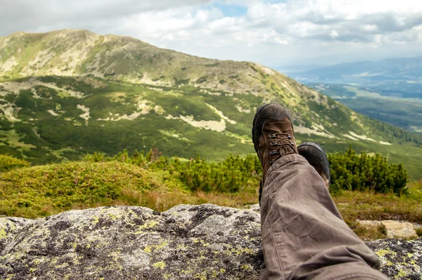 而休息在山里徒步旅行者的登山靴 免版税图库图片