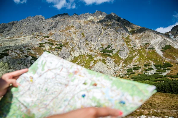 Turista nas montanhas ler o mapa — Fotografia de Stock