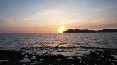 Mallorca Adası 'nın deniz üzerindeki günbatımının havadan görünüşü. Uzakta yüksek kayalıklar, suda kayıklar. Mallorca 'nın Rocky plajı. Hava, deniz manzaralı..