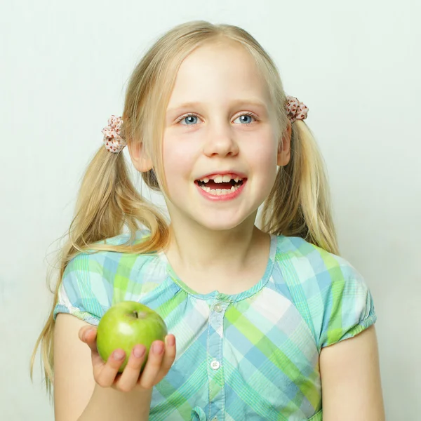 Laughing little girl with green apple — Stock Photo, Image