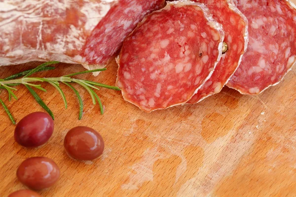 Comida italiana: salami, romero y aceitunas — Foto de Stock