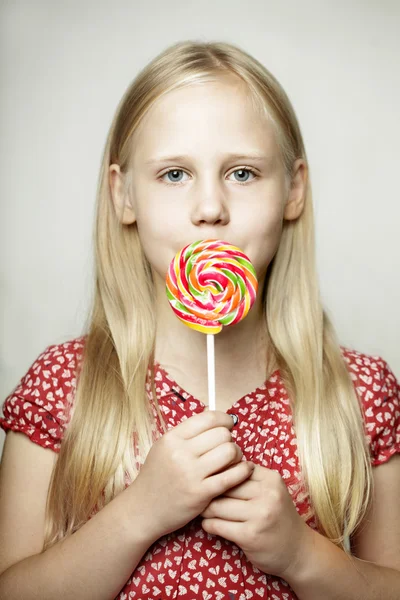 Mooi meisje met snoep, grappig gezicht — Stockfoto