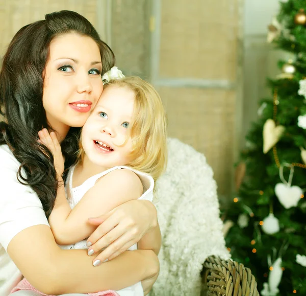 Madre abrazando hija en fondo de Navidad —  Fotos de Stock