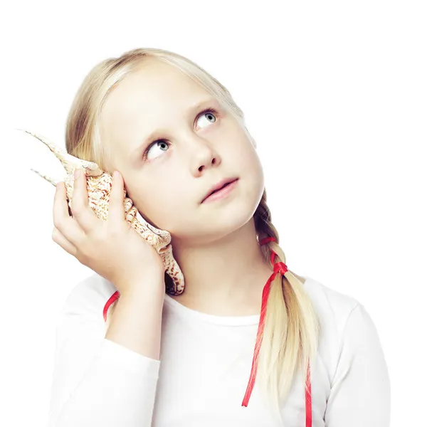Niño sosteniendo una concha en su oído, concepto de comunicación —  Fotos de Stock