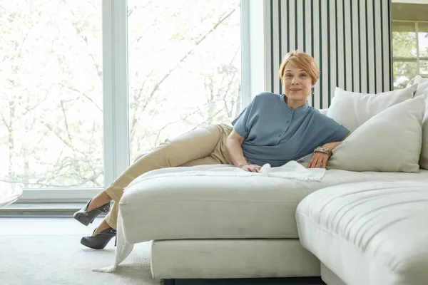 Glad Mogen Kvinna Sitter Soffan Och Tittar Kameran Elegant Dam — Stockfoto