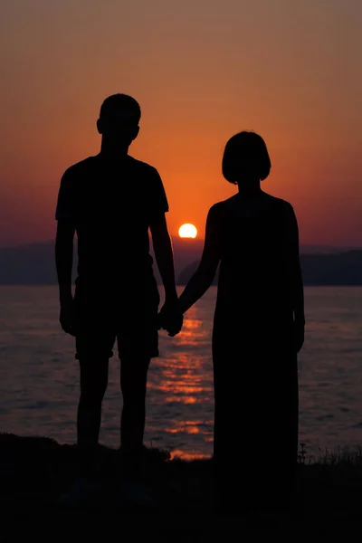 若いです幸せなカップルに夕日の海のビーチ — ストック写真