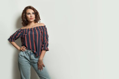 Gri arka planda poz veren güzel model kadın.